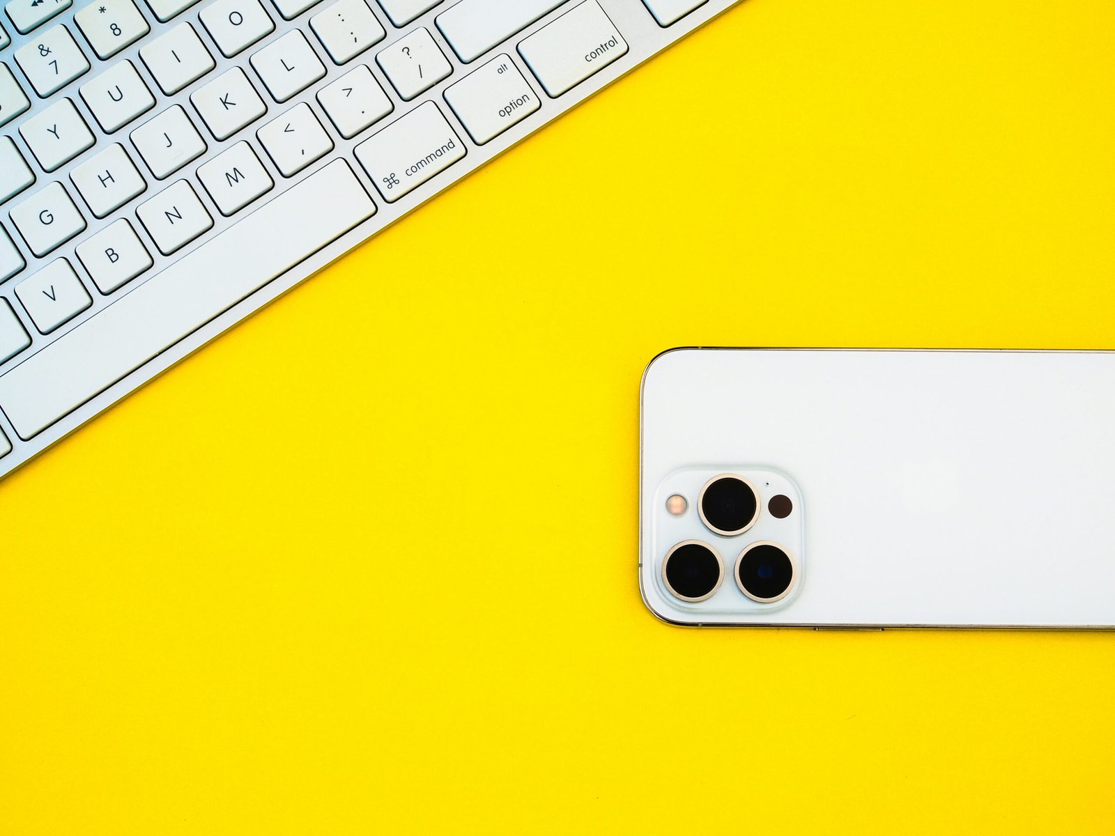 a white iphone sitting a white iphone sitting on top of a yellow table